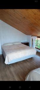 a bedroom with a large bed with a wooden ceiling at Mindo Suites in Mindo