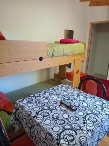 a room with a bunk bed and a table at Dormis in Perito Moreno