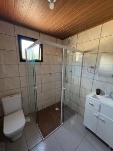 a bathroom with a shower and a toilet and a sink at Cobertura Vista mar com churrasqueira in Governador Celso Ramos