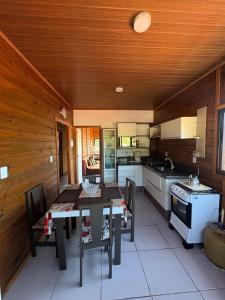 a kitchen with wooden walls and a table and chairs at Cobertura Vista mar com churrasqueira in Governador Celso Ramos +13 photos