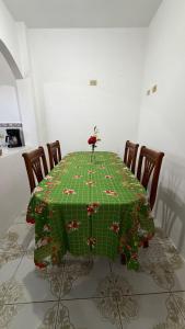 a dining room table with a green christmas tablecloth at Casa JIREH in Puerto Ayora