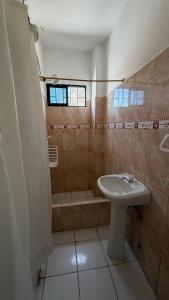 a small bathroom with a sink and a shower at Casa JIREH in Puerto Ayora