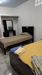 a room with two beds and a mirror at Casa JIREH in Puerto Ayora