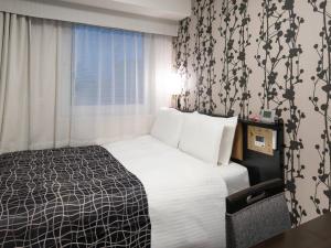 a hotel room with a bed and a window at APA Hotel Nihombashi Bakurocho Ekimae in Tokyo
