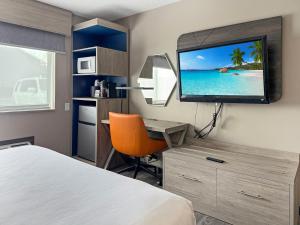 een hotelkamer met een bed en een flatscreen-tv bij Reston Inn & Suites in Spencer