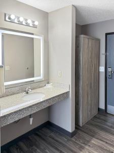 een badkamer met een wastafel en een spiegel bij Reston Inn & Suites in Spencer