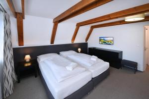 een slaapkamer met een groot bed met witte lakens bij Penzión Chata Valaška in Stary Smokovec +103 foto's