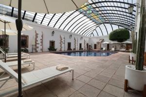a swimming pool in a building with a glass ceiling at Hacienda Lagunillas in Querétaro