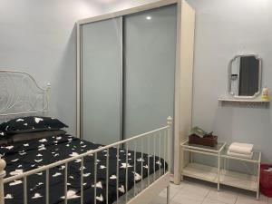 a small bedroom with a bed and a mirror at Roma Guesthouse Terrace With 3 Bedroom & Airconditioning in Shah Alam