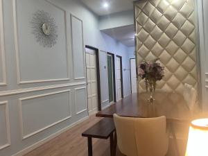 a dining room with a table and a vase of flowers at Roma Guesthouse Terrace With 3 Bedroom & Airconditioning in Shah Alam +2 photos