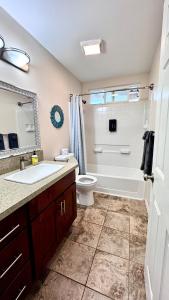 a bathroom with a tub and a toilet and a sink at 2BR 1BA Blissful Orchard in Keaau