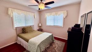 a bedroom with a bed and a ceiling fan at 2BR 1BA Blissful Orchard in Keaau