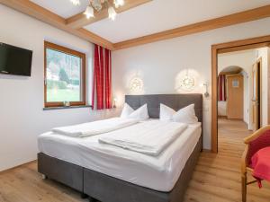 une chambre avec un grand lit et une télévision dans l'établissement Landhaus Marchfeld Top 1, à Wildschönau