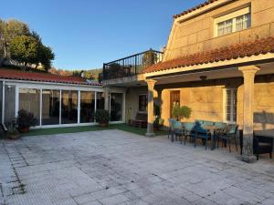a patio with a table and chairs next to a building at Casa Santa Ana in Pontevedra
