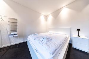 a white bedroom with a bed with white sheets at Lea Apartement - Ruhiges Studio in Schaffhausen