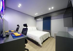 a bedroom with a bed and a desk with a computer at Hotel MERV in Seryu-dong +7 photos