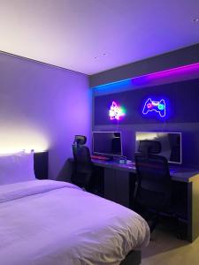 a bedroom with a bed and a desk with two monitors at Hotel MERV in Seryu-dong