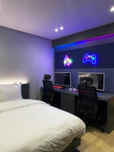 a bedroom with a bed and a desk with two monitors at Hotel MERV in Seryu-dong