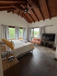 a bedroom with a bed and a flat screen tv at Estancia de Cafayate Wayra Huasi in Cafayate +69 photos