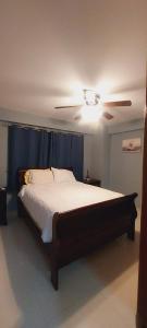 una camera con un grande letto e un ventilatore a soffitto di Cozy & Charming a Santo Domingo