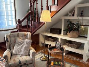 a living room with a chair and a lamp at Casa Santa Ana in Pontevedra