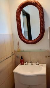 ein Badezimmer mit Waschbecken und Spiegel in der Unterkunft La Dominga in La Granja