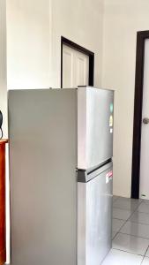 a stainless steel refrigerator sitting in a room at Book Lanta House in Ban Ru Yai