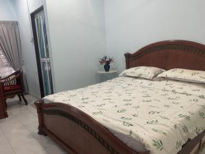 a bedroom with a large bed with a wooden headboard at Roma Guesthouse Terrace With 3 Bedroom & Airconditioning in Shah Alam