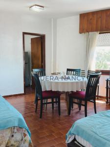 ein Esszimmer mit einem Tisch und vier Stühlen in der Unterkunft Urquiza 263 P4 SB in San Bernardo