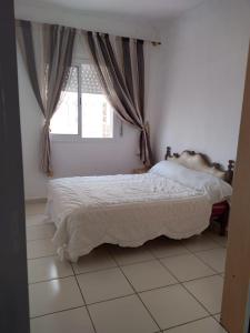 een slaapkamer met een bed voor een raam bij Private Room near Mohammed V - Marrakech in Marrakesh