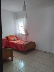 een slaapkamer met een bed met een rode sprei en een raam bij Private Room near Mohammed V - Marrakech in Marrakesh