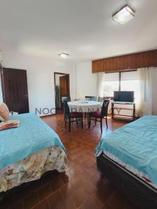 ein Schlafzimmer mit zwei Betten und einem Tisch und Stühlen in der Unterkunft Urquiza 263 P4 SB in San Bernardo