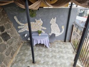 un patio avec une table et des chats peints sur le mur dans l'établissement El Chalet del Gato, apartamento 3, à Viña del Mar