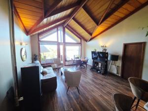 een woonkamer met houten vloeren en een groot raam bij Casa Rio Valdivia in Valdivia