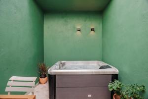 een badkuip in een groene kamer met planten bij Medellinn The Blooming Hotel in Medellín