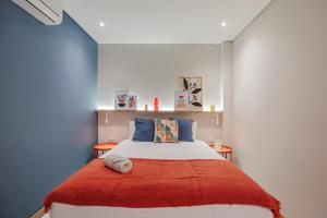 een slaapkamer met een bed met een rode deken bij Medellinn The Blooming Hotel in Medellín