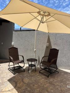 two chairs and a table under an umbrella at Apartamento Amplo em Tramandaí in Tramandaí +5 photos