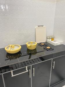 a kitchen with two yellow bowls on a counter at RusanHome Pengkalan Chepa in Pengkalan Cepa