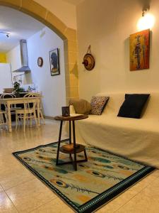 a living room with a bed and a table at Adinkra Suits in Ħal Balzan