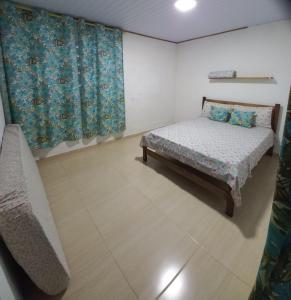 a small bedroom with a bed and a window at Picinguaba Beleza Intocada in Ubatuba