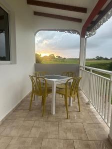una sala da pranzo con tavolo e sedie su un balcone di Les gites de Saint Michel - Purple a Grand-Bourg