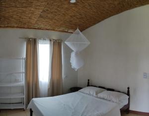 una camera da letto con un letto con lenzuola bianche e un soffitto di Hills Villa Rio Celeste a Rio Celeste