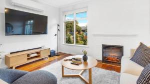 a living room with a couch and a fireplace at Sunnybank House with EV Charger in Cheltenham
