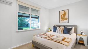 a bedroom with a large bed and a window at Sunnybank House with EV Charger in Cheltenham