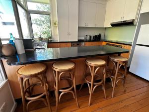 una cucina con piano di lavoro nero e sgabelli di Entire Beachfront Vacation House a McCrae Altre 6 foto