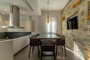 a kitchen with a dining table and a brick wall at Lindos 4 me Villa in Lindos