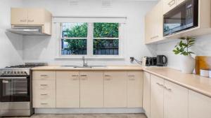 a kitchen with white cabinets and a sink at Sunnybank House with EV Charger in Cheltenham