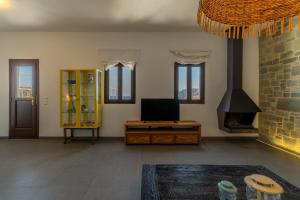 a living room with a tv and a fireplace at Lindos 4 me Villa in Lindos