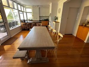 un lungo tavolo in legno in una stanza con sedie di Entire Beachfront Vacation House a McCrae