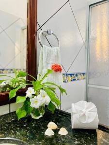 un lavandino in bagno con vaso di fiori e asciugamano di Casa Caju a Aracati